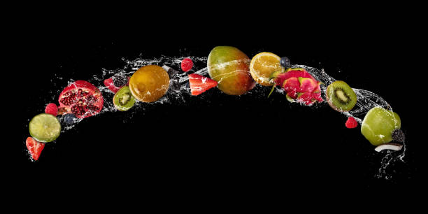 istock Pieces of fruit in water splash, isolated on black background 940967386