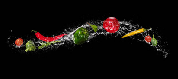 istock Mix of vegetable in water splash on black background. 940967500