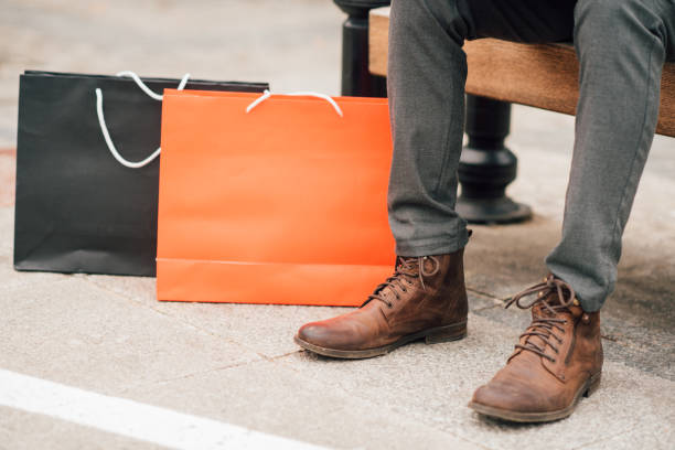 istock Shopaholic man sitting on a bench after shopping 940968618