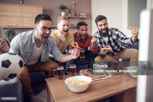 Amigos Divirtiéndose En Casa Foto de stock y más banco de imágenes de Fútbol - Fútbol, Televisión, Pelota de fútbol