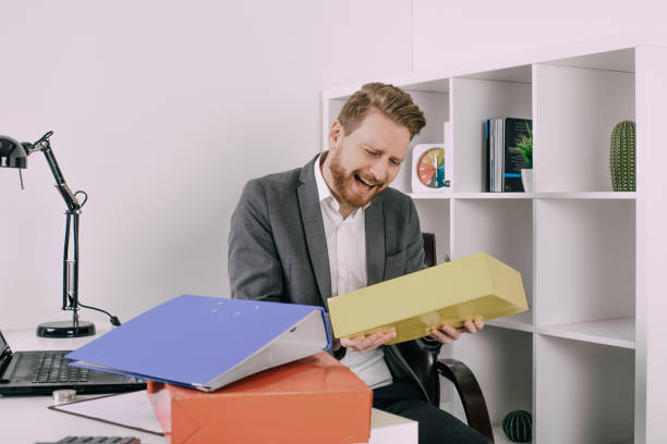 istock Laughing business man handling files 940971746