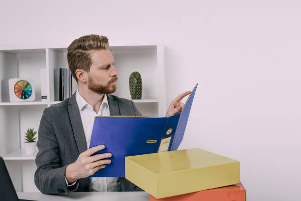 istock Serious business man pointing at a file 940971766