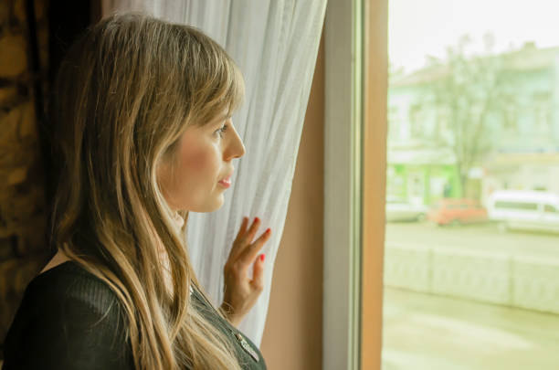 istock women looking out behind the cafe window 940983068