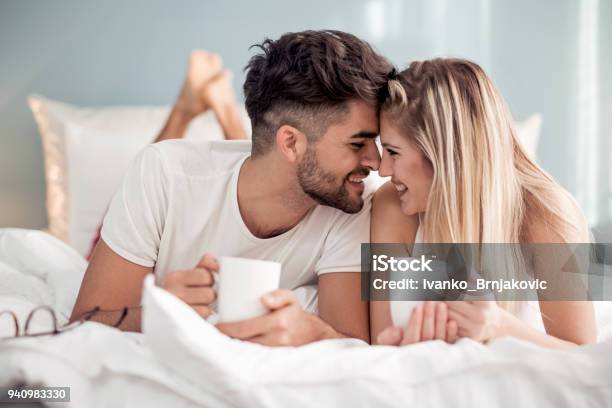 Dulce Pareja Joven Acostado En El Dormitorio Foto de stock y más banco de imágenes de Parejas - Parejas, Hotel, Cama