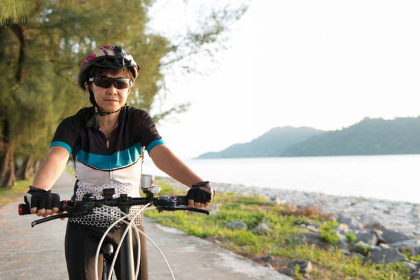 istock Joyful senior woman riding a bicycle 940985678