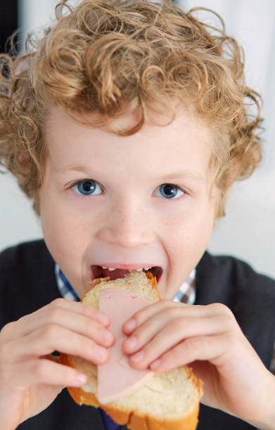 istock Little Caucasian boy closed his eyes with pleasure while eating 940995852