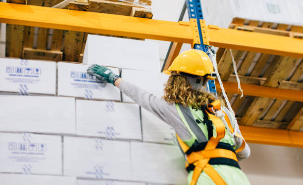 istock Young female manual worker hanging on a climbing rope in warehouse 940996186