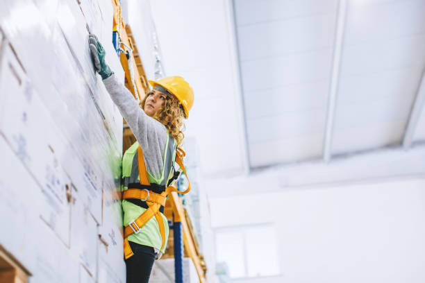 istock Young female manual worker hanging on a climbing rope in warehouse 940996188
