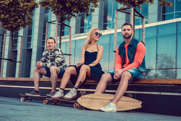 istock Blond female on longboard and two males posing. 941004228