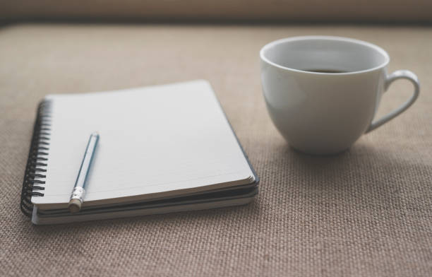 istock Coffee in white cup with Journal book and pencil 941004898