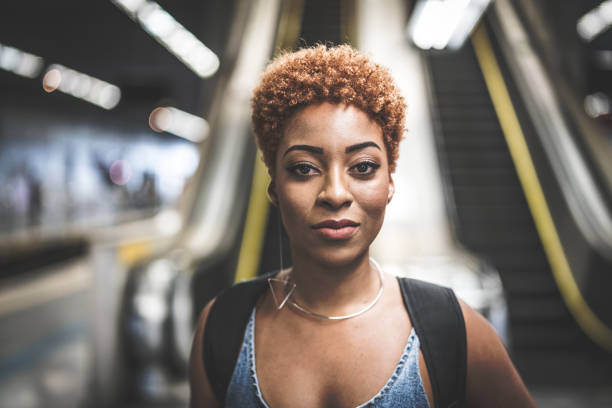 retrato de mulher jovem afro na estação de metro - cabelo pintado de vermelho - fotografias e filmes do acervo