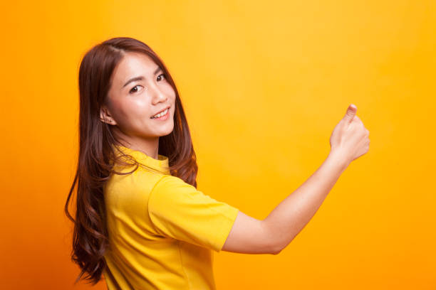 istock Young Asian woman turn back thumbs up. 941016718