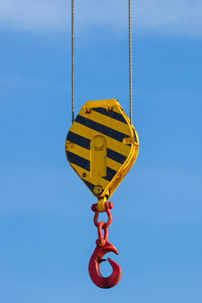 Lifting block with hook Black and yellow striped lifting block with a red hook in front of a blue sky hook of holland stock pictures, royalty-free photos & images