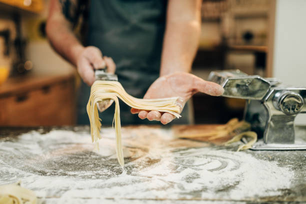 istock Chef cooking fettuccine in pasta machine 941021220