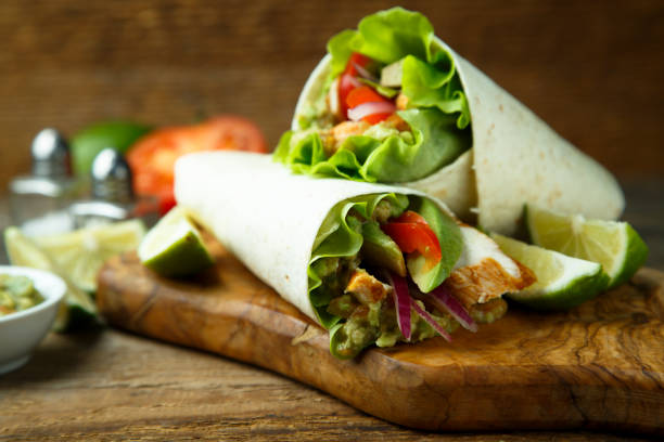 Chicken wraps Chicken wraps with green salad and vegetables mexican culture food mexican cuisine fajita stock pictures, royalty-free photos & images