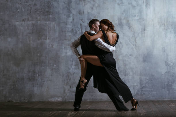 young pretty woman in black dress and man dance tango - retro revival couple men elegance imagens e fotografias de stock