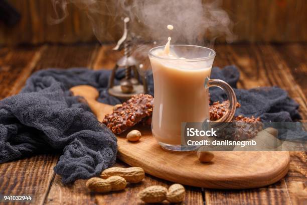 Té Con Galletas En Un Vaso De Vidrio Con Un Chapoteo Sirve El Desayuno En Una Hermosa Tabla Con Un Nogal En El Fondo Una Taza De Fumar De Té En Un Fondo De Madera Foto de stock y más banco de imágenes de Té - Bebida caliente