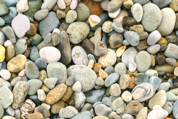 istock Smooth round pebbles sea texture background. Pebble on a beach. Gravel stone seashore. 941044164