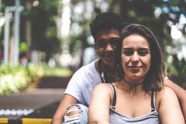istock Lesbian Couple Sitting on Bench Park 941047330