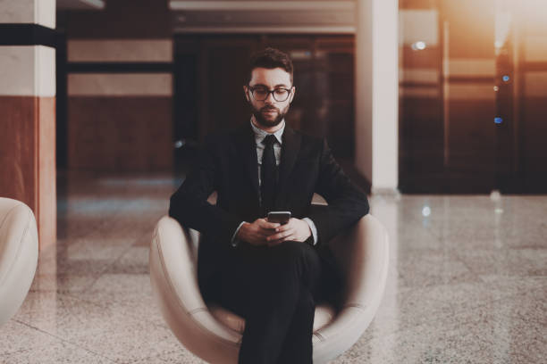 istock Businessman with smartphone in office armchair 941047762