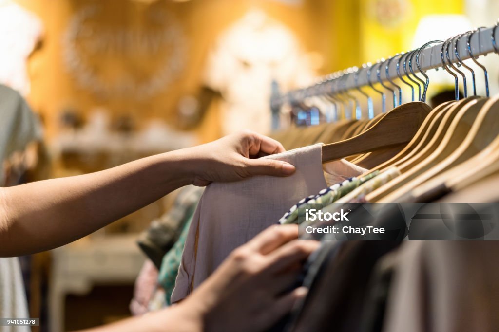 Nahaufnahme von Hand auswählen Sparsamkeit junge Frau und Rabatt T-shirt Kleider im Store suchen oder kaufen billige Baumwollhemd auf Rack Kleiderbügel auf Flohmarkt, stall-shopping Bekleidung Mode-Konzept - Lizenzfrei Kleidung Stock-Foto
