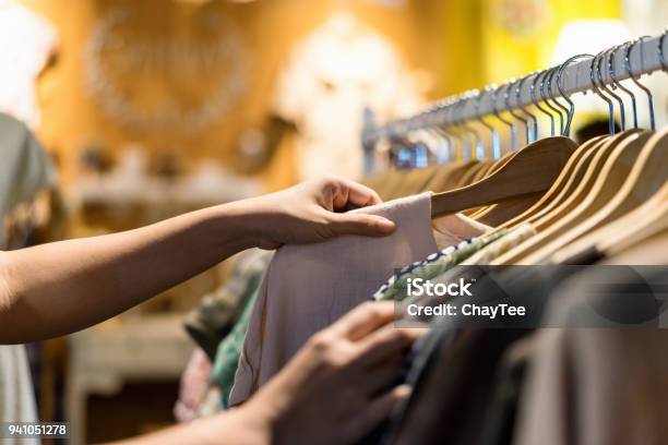 Primo Piani Di Donna Mano Scegliendo Parsimonia Giovani E Sconto Tshirt Vestiti In Negozio Ricerca O Acquisto Di Camicia Di Cotone A Buon Mercato Su Appendiabiti A Cremagliera Al Mercato Delle Pulci Stallo Shopping Abbigliamento Moda Concetto - Fotografie stock e altre immagini di Abbigliamento