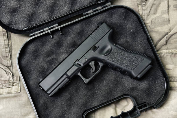 pistola 9mm, serie di armi da pistola, primo piano della pistola della polizia su sfondo mimetico. - handgun gun m9 9mm foto e immagini stock