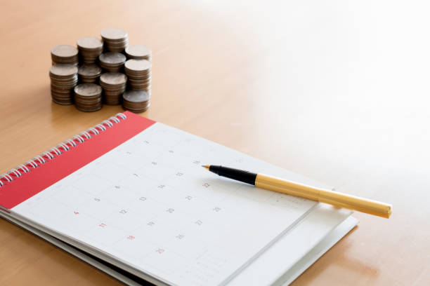 istock Pen and coins on calendar 941055222