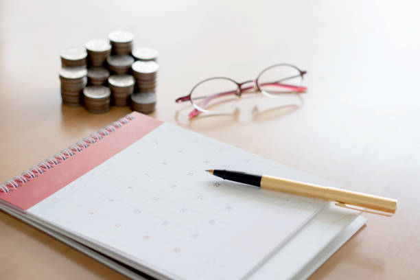 istock Pen and coins on calendar 941055326