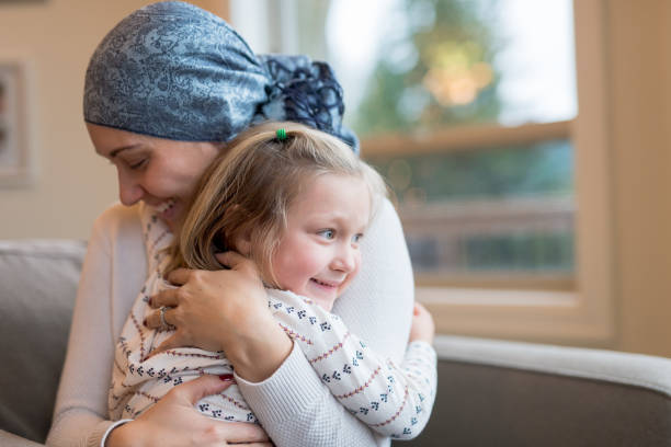 la giovane mamma etnica con il cancro tiene stretta la figlia - cancer women womens issues friendship foto e immagini stock