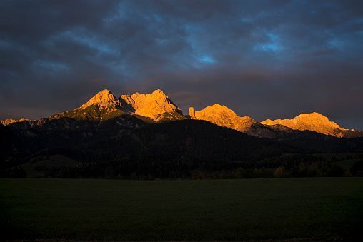 a reddish glow seen near sunset on the summits of mountains. Here some summits in Salzburg, Austria at the region of Zell am See.