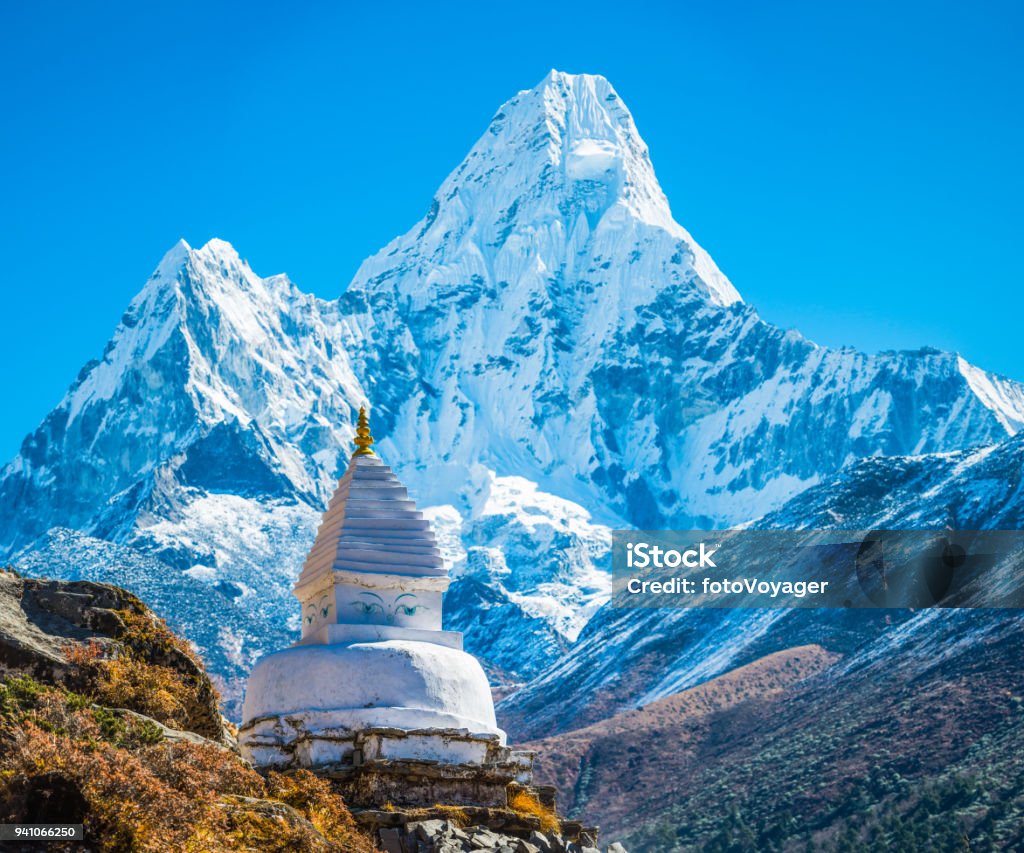 Buddhist stupa shrine below Ama Dablam mountain peak Himalayas Nepal Traditional white-washed Buddhist stupa and mani stones high in the thin mountain air above the Khumbu valley overlooked by Ama Dablam (6812m) deep in the remote Himalayan wilderness of the Sagarmatha National Park, a UNESCO World Heritage Site, Nepal. Stupa Stock Photo