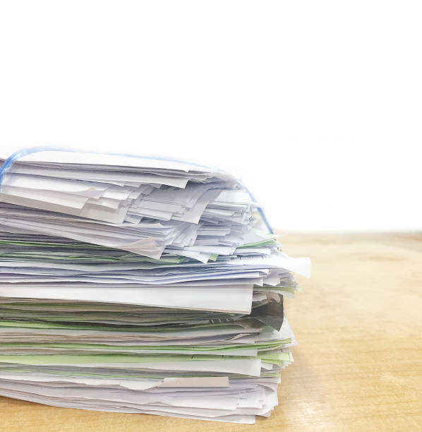 istock Stack of business paperwork on wood background 941071880