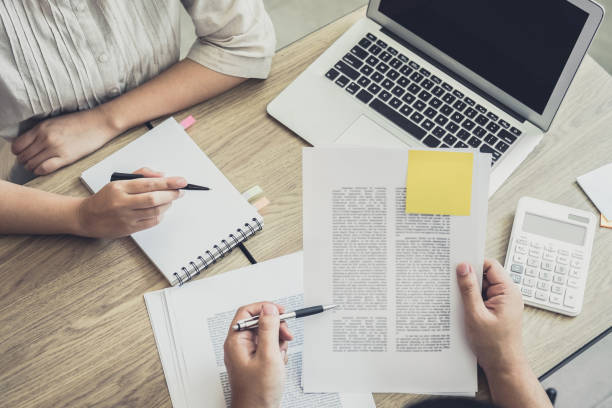 istock Young students campus or classmates with helps friend studying for a test an exam in workbook learning in classroom, Tutor books with friends, Education school concept 941073314