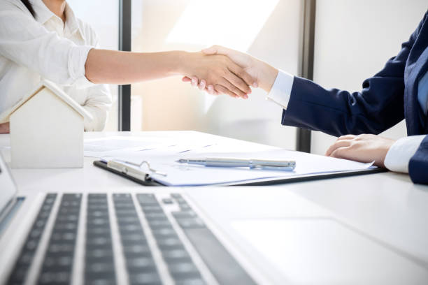 istock Handshake after good cooperation, Real estate broker residential agent shaking hands with customer after good deal agreement house rent listing contract 941073344