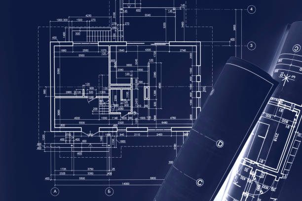 istock civil building sketch drawings, rolled blueprints on dark blue surface. architect workplace background. 941085080