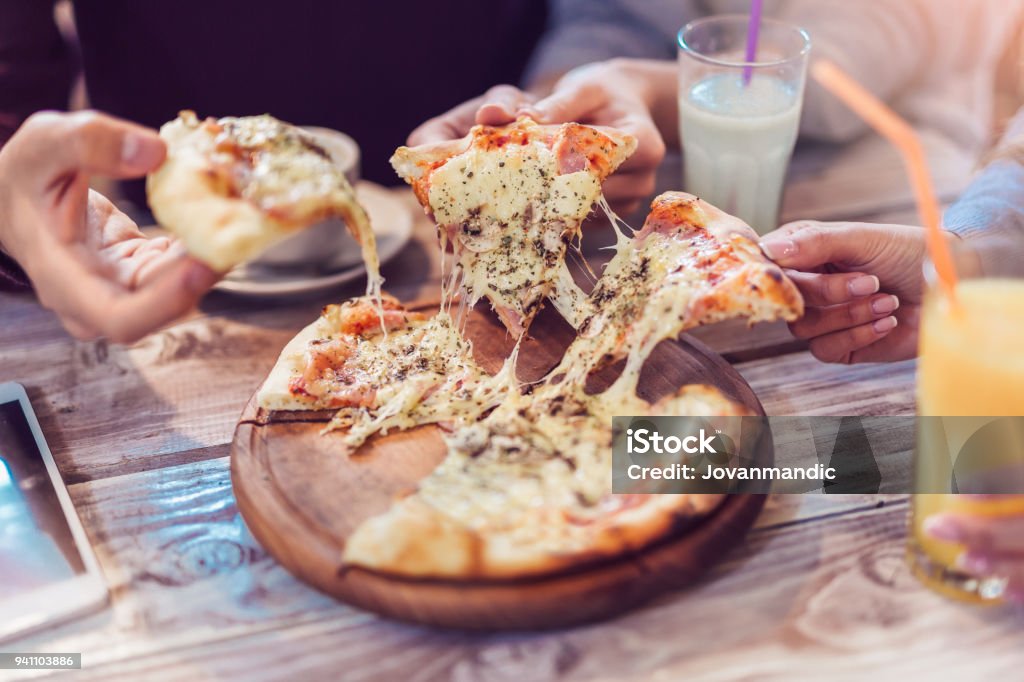 Close-up Of People Hands Taking Slices Of Pizza Eating Food. Close-up Of People Hands Taking Slices Of Pizza. Group Of Friends Sharing Pizza Together. Pizza Stock Photo