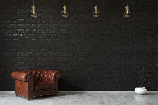 Brown leather armchair against black brick wall