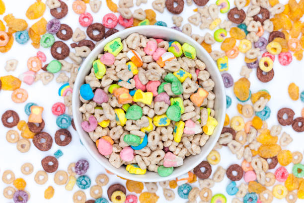 Bowl of cereals and marshmallows on white background Bowl of cereals and marshmallows and cereals scattered around the table on white background. Top view. good luck charm photos stock pictures, royalty-free photos & images