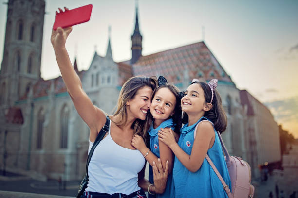 istock Mother and her daughters are hugging and taking selfie/making video call 941116220