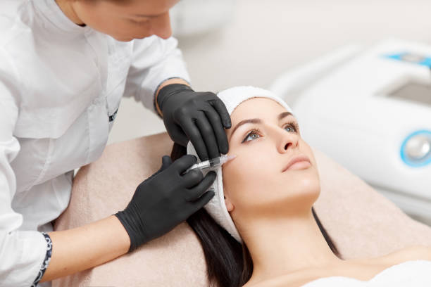 istock Beautician making anti-wrinkle injection in woman's face 941121312