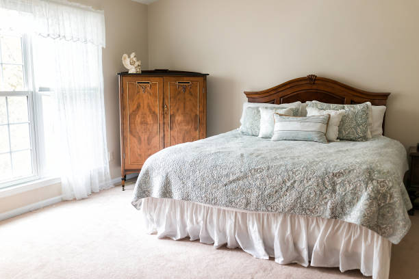 istock New bed comforter with headboard, decorative pillows, window, in bedroom in staging model home, house or apartment, sunlight 941127886
