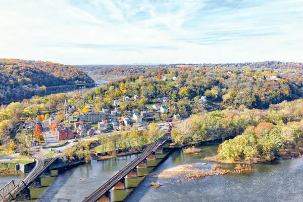 Harper's Ferry overlook with colorful orange yellow foliage fall autumn forest with small village town by river in West Virginia, WV