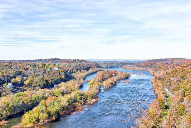 Photo of Harper's Ferry overlook with colorful orange yellow foliage fall autumn forest with small village town by Potomac river blue in West Virginia, WV