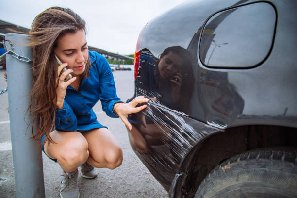 donna stare vicino auto graffiato. chiamare i aiuto. assicurazione auto - driving mobile phone car talking foto e immagini stock