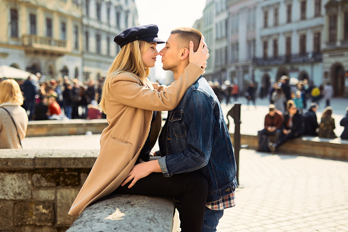 Lovely couple stand on city landscape and hug each other with sun on background