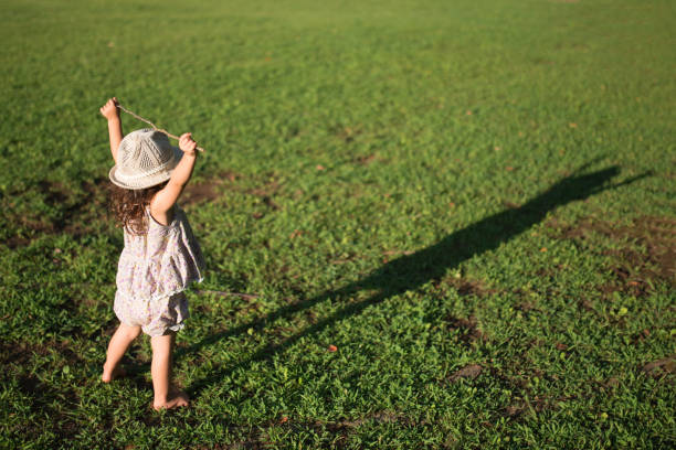 芝生で遊ぶ女の子 - 子ども　成長 ストックフォトと画像