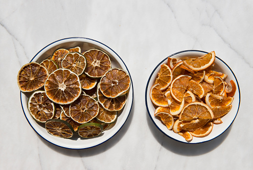 Dried mandarin and lemon on white table.