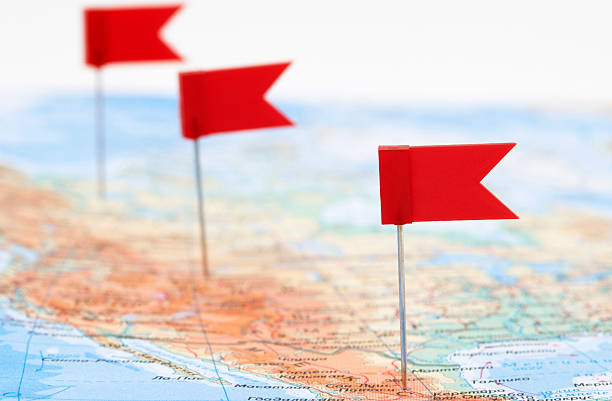 selective focus of colorful flags pinned on world map