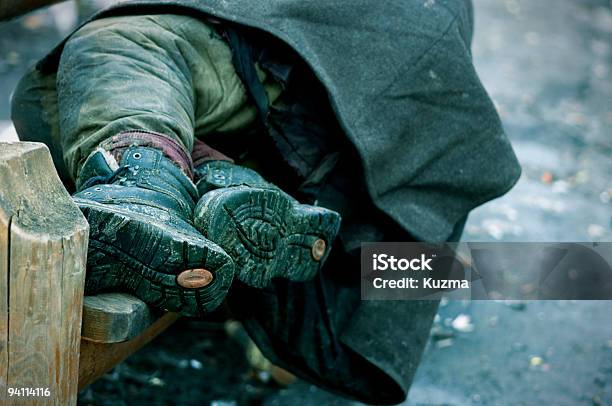 A Photograph Of A Homeless Mans Legs On A Bench Stock Photo - Download Image Now - Homelessness, Winter, Homeless Person